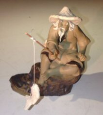 Ceramic Figurine - Mud Man Sitting On A Rock Fishing