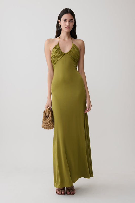Woman wearing a green gathered slinky maxi dress.