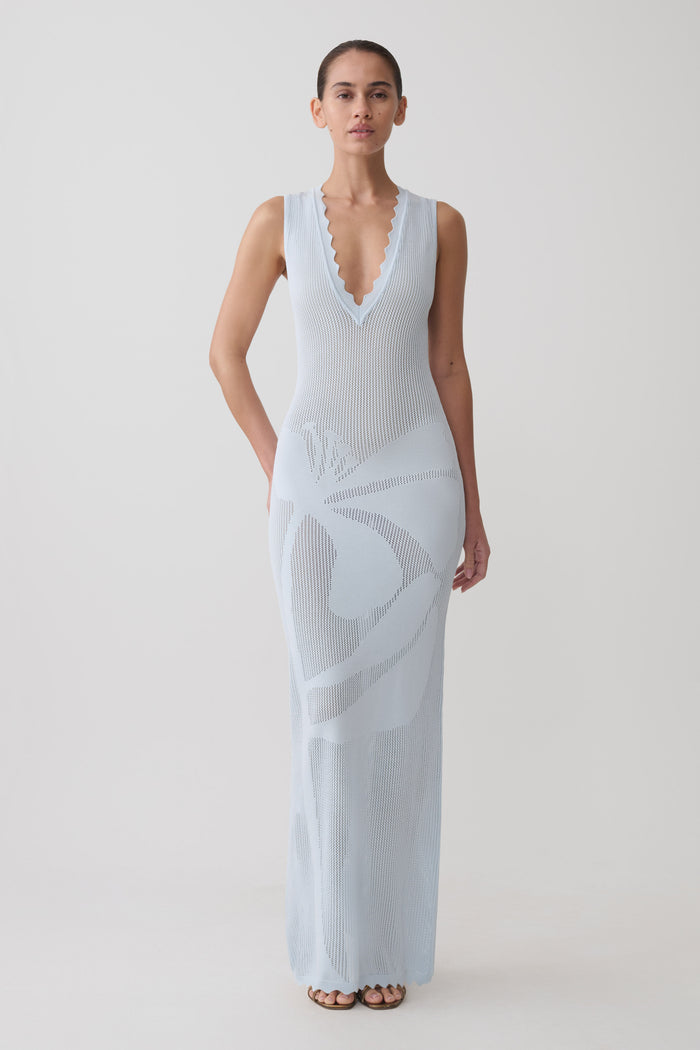Woman wearing a light blue floral knit maxi dress.