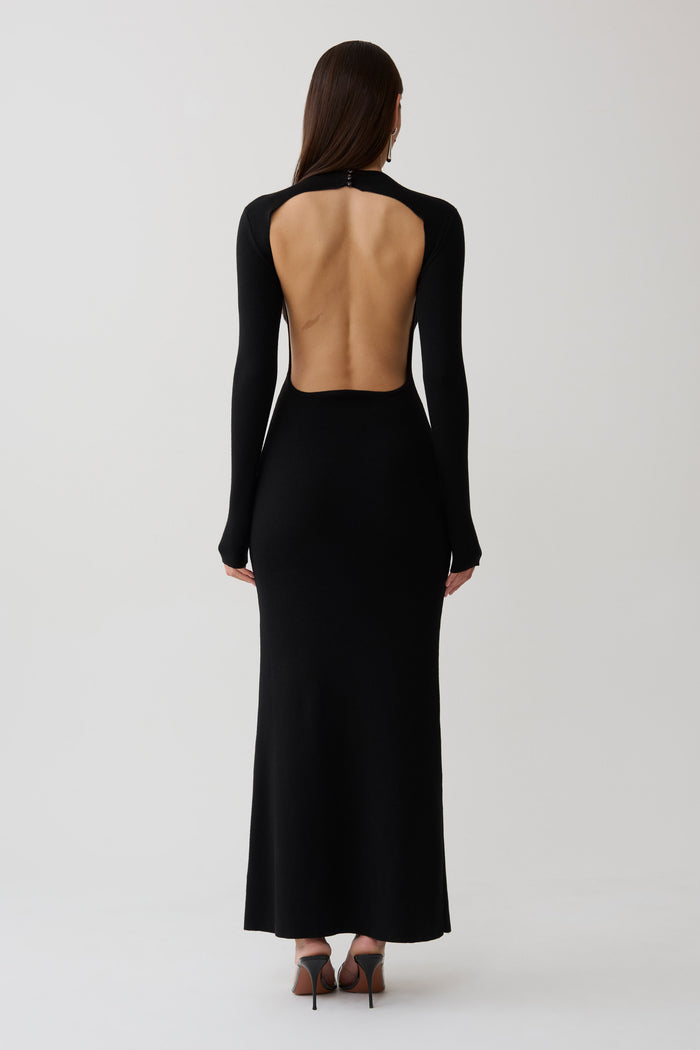 Woman wearing a black long sleeve knit maxi dress.